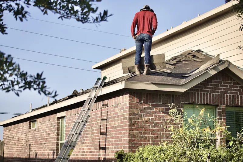 Professional roofer working on a residential roof in Campus Hill Farms